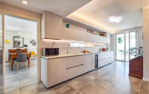 a kitchen with white cabinets and a dining room at 3 Bedroom Stunning Home In Lazise in Lazise