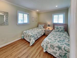 a bedroom with two beds and a mirror at Sea Urchin 39 in Saint Augustine +24 photos