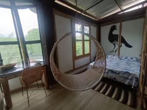 a room with a hammock in a room with a bed at Bio Coliving Tayrona, Eco Retreat for You or Your group with Fast, Reliable WiFi & Power in Nature in Santa Marta