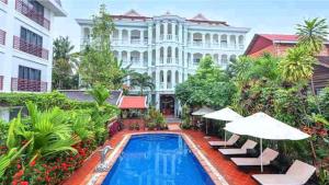 un hotel con piscina frente a un edificio en Tan Sokchea Boutique, en Siem Reap