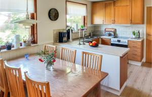 a kitchen with a table with chairs and a counter top at 4 Bedroom Amazing Home In Falsterbo in Skanör med Falsterbo