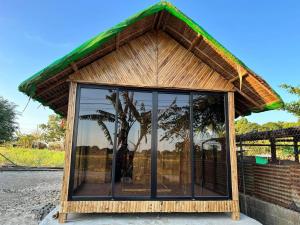 ein kleines Gebäude mit einem Glasfenster an einer Straße in der Unterkunft Tiny house Calatagan in Calatagan