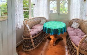 a room with three wicker chairs and a table with a table at Bolmen in Bolmen
