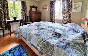 a bedroom with a bed with a blue and white quilt at Bolmen in Bolmen +3 photos