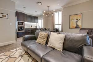 a living room with a leather couch and a kitchen at Explore the Blue Mountains on foot in Katoomba