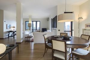 a dining room and living room with a table and chairs at Appartamento Il Parco Cernobbio in Cernobbio