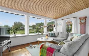 a living room with a couch and a table at Beautiful Home In Gudhjem in Gudhjem