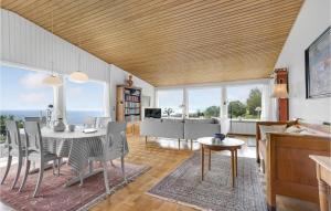 a dining room and living room with a table and chairs at Beautiful Home In Gudhjem in Gudhjem