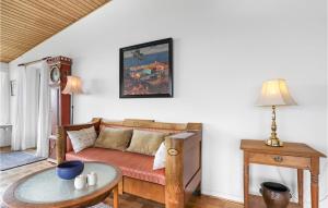 a living room with a couch and a table at Beautiful Home In Gudhjem in Gudhjem