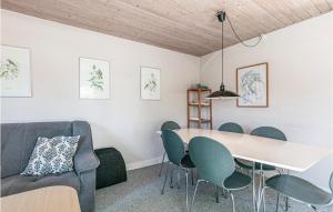 a living room with a dining room table and chairs at Risegård, Lejl B in Åkirkeby
