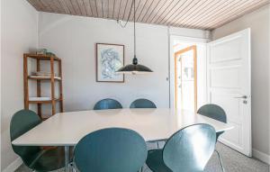 a dining room with a white table and blue chairs at Risegård, Lejl B in Åkirkeby +7 photos