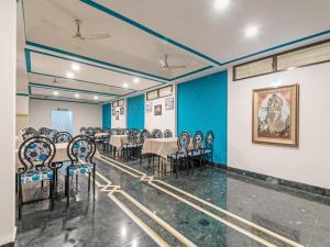 a room with tables and chairs and a painting on the wall at Hotel Indore Palace - Newly Renovated Hotel in Shirdi