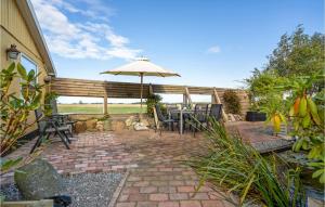 un patio con ombrellone, tavolo e sedie di 6 Bedroom Cozy Home In Dannemare a Dannemare