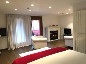 a bedroom with a living room with a fireplace at Hotel Del Lago in Puigcerdà +84 photos
