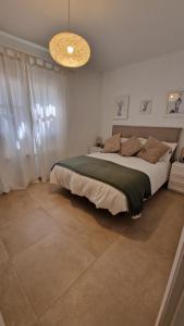 a bedroom with a large bed and a chandelier at La Islita in Playa Blanca