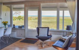 a living room with chairs and a table and windows at Nice Home In Rudkøbing With Wifi in Spodsbjerg