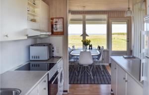 a kitchen with a table and a dining room at Nice Home In Rudkøbing With Wifi in Spodsbjerg