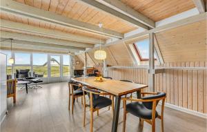a dining room with a wooden table and chairs at Holiday Home Hvide Sande With A Fireplace 05 in Bjerregård