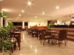a restaurant with tables and chairs and a bar at Phu View Talay Resort in Pattaya South