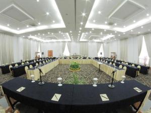 a large banquet hall with a black table and chairs at Puri Mega Hotel in Jakarta