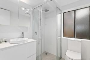 Un baño blanco con lavabo y ducha. en Mowamba B4, en Thredbo 11 fotos más