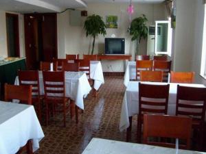 a dining room with tables and chairs and a television at GreenTree Inn Anqing Renmin Road Commercial Street Express Hotel in Anqing