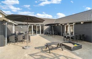 a patio with an umbrella and a table and chairs at Lovely Home In Løkken With Wifi in Løkken +31 photos