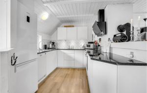 ブラーバンドにあるAmazing Home In Blåvand With Kitchenの白いキャビネット付きのウッドフロアの白いキッチン