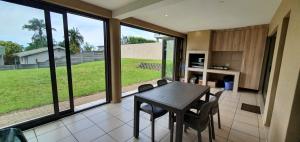 a kitchen with a table and chairs and a large window at Sea Breeze West in Margate