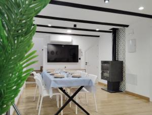 a dining room with a table and chairs and a tv at La BUHARDILLA DE CHARLIN in Casas de Ves