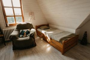 a room with two beds and a chair in a attic at Zlatorudná chalupa in Bruntál
