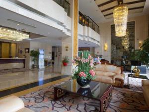 a lobby with a couch and a table with flowers on it at Chengdu Handu International Hotel in Chengdu