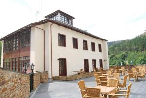 a building with chairs and tables in front of it at Hotel Mirador de Barcia in Ribeira de Piquin