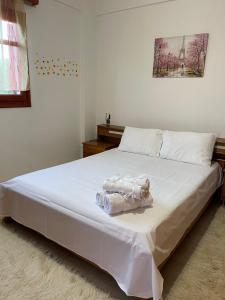 a bedroom with a large bed with white sheets at Patritsia in Gázion