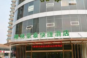 a building with a sign in front of it at GreenTree Inn Jiangsu Wuxi New District High Speed Rail Station Newland Family Express Hotel in Wuxi