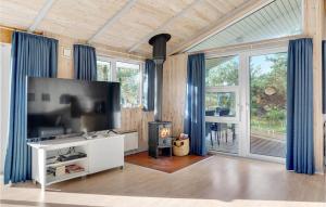 a living room with a flat screen tv and a fireplace at Holiday Home Svenskerstræde Rømø I in Rømø Kirkeby