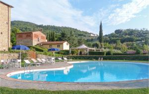 a large swimming pool with chairs and a house at Il Marinocchio Di Malatesti in Arezzo