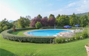 a swimming pool in a yard with umbrellas at Il Marinocchio Di Malatesti in Arezzo