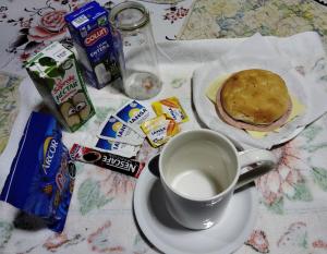 a cup of coffee and a sandwich on a table at Pensión San Andrés in Concepción