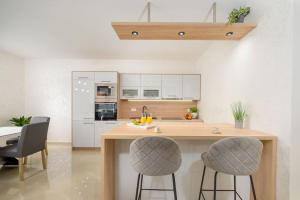 a kitchen with a wooden counter and two bar stools at Villa Putina by IstriaLux in Svetvinčenat