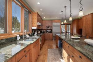 a large kitchen with wooden cabinets and granite counter tops at Stagecoach Cabin home in Fraser