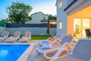 a group of chairs and a swimming pool at Villa Putina by IstriaLux in Svetvinčenat