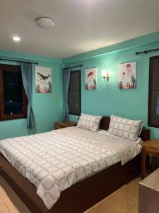 a bedroom with a large bed with blue walls at Dreamcatcher Bungalow in Bophut +24 photos