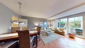 a dining room and living room with a table and chairs at Haus Sansibär in Wenningstedt