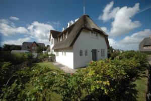 ein kleines weißes Haus mit einem Strohdach in der Unterkunft Landhaus Strandhafer HT 1 in Wenningstedt-Braderup