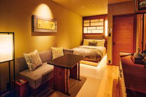 a living room with a couch and a bed in a room at Sora Niwa Terrace Kyoto Bettei in Kyoto
