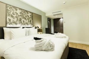 two beds in a hotel room with towels on them at Quality Hotel Sveitsi in Hyvink&auml;&auml;