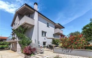 a white house with stairs and flowers at 2 Bedroom Cozy Apartment In Pula in Veli Vrh +28 photos