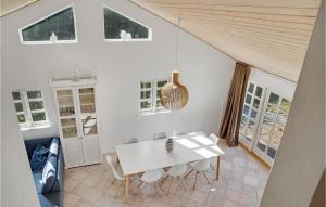 una sala da pranzo bianca con tavolo e sedie bianchi di Cozy Home In Væggerløse With Sauna a Bøtø By