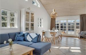 un soggiorno con un divano blu e un tavolo di Cozy Home In Væggerløse With Sauna a Bøtø By